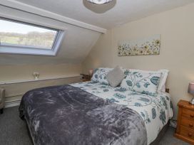 A bedroom with a double bed and a window at Penlone Cottage Rhayader