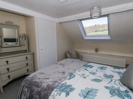 A bedroom with a bed and dresser at Penlone Cottage in Rhayader