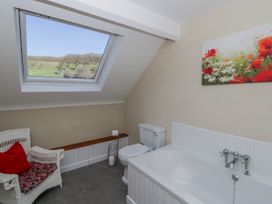 A bathroom with a bathtub and a toilet at Penlone Cottage in Rhayader