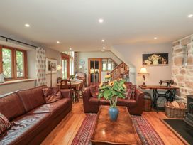 A living room with a sofa, table, and chairs at The Lodge Farm Barn Deepdean near Ross-on-Wye