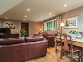 A living room with a sofa and dining table at The Lodge Farm Barn Deepdean near Ross-on-Wye