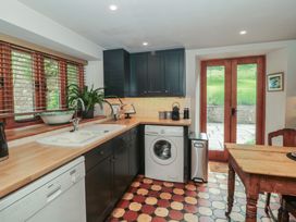 A kitchen with a sink and washing machine at The Lodge Farm Barn Deepdean near Ross-on-Wye