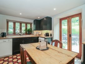 A kitchen with a wooden table and chairs at The Lodge Farm Barn in Deepdean near Ross-on-Wye