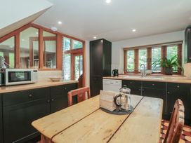 A kitchen with a table and chairs at The Lodge Farm Barn near Deepdean