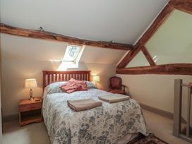 A bedroom with a bed and bedside table at The Lodge Farm Barn Deepdean near Ross-on-Wye
