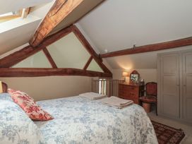 A bedroom with a bed and dresser at The Lodge Farm Barn Deepdean near Ross-on-Wye