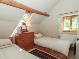 A bedroom with two beds and a dresser at The Lodge Farm Barn in Deepdean near Ross-on-Wye