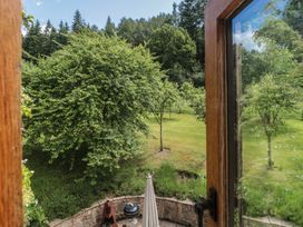 A garden view with trees and a barbecue at The Lodge Farm Barn in Deepdean near Ross-on-Wye