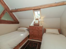 A bedroom with two single beds and a dressing table at The Lodge Farm Barn Deepdean near Ross-on-Wye