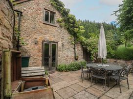 An outdoor patio with a table and chairs at The Lodge Farm Barn Deepdean near Ross-on-Wye