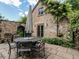 An outdoor seating area with a table and chairs at The Lodge Farm Barn Deepdean near Ross-on-Wye