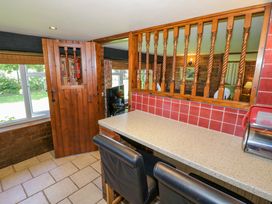 A kitchen with a serving window and bar stools at Severn Bank Lodge Astley Burf near Stourport-on-Severn