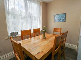 A dining room with a wooden table and chairs at Halford Hill in Llanberis