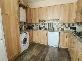 A kitchen with wood cabinets and appliances at Halford Hill in Llanberis