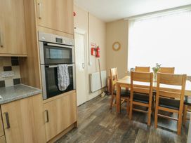 A kitchen with an oven and dining table at Halford Hill in Llanberis