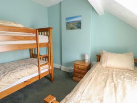 A bedroom with a bunk bed and a single bed at Halford Hill in Llanberis