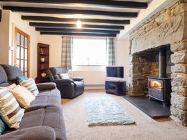 A living room with a sofa and a fireplace at Bryn Re, Trawsfynydd near Llan Ffestiniog and Dolgellau