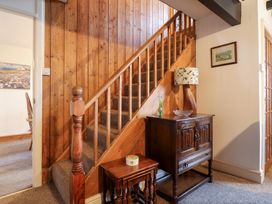 A hallway with a staircase and wooden furniture at Bryn Re in Trawsfynydd near Llan Ffestiniog and Dolgellau