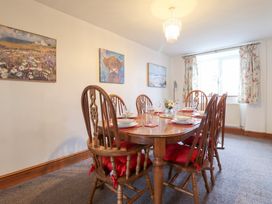 A dining room with a wooden table and chairs at Bryn Re in Trawsfynydd near Llan Ffestiniog and Dolgellau