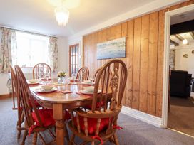 A dining room with a wooden table and chairs at Bryn Re in Trawsfynydd near Llan Ffestiniog and Dolgellau