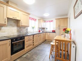 A kitchen with cabinets, countertop, and a table at Bryn Re in Trawsfynydd near Llan Ffestiniog and Dolgellau