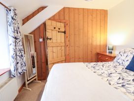 A bedroom with a bed and wooden door at Bryn Re Trawsfynydd near Llan Ffestiniog and Dolgellau