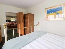 A bedroom with a bed and an open door leading to another room at Blaenffynnon Bach in Trelech near Crymych