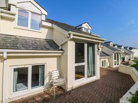 Exterior view of a row of cream-colored houses with slate roofs and white-framed windows and doors at Beachcombers in Porth