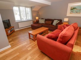 A living room with two sofas a coffee table a television and a framed picture on the wall at Beachcombers in Porth
