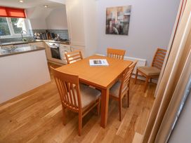 A kitchen and dining area with wooden table and chairs near a window at Beachcombers in Porth
