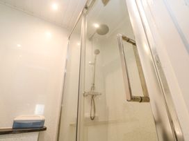 A shower enclosure with a glass door and chrome handle at Beachcombers in Porth