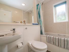 A bathroom with a sink toilet bathtub and a window at Beachcombers in Porth