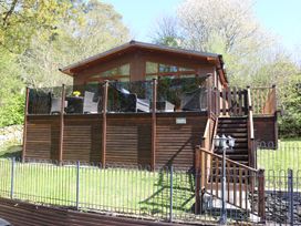 A lodge with a deck and stairs at High View Lodge in White Cross Bay near Troutbeck Bridge
