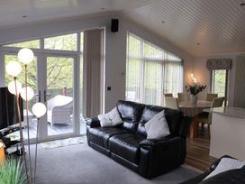 A living room with a sofa and a dining table at High View Lodge White Cross Bay near Troutbeck Bridge