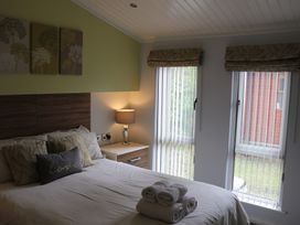 A bedroom with a bed and bedside table at High View Lodge near Troutbeck Bridge