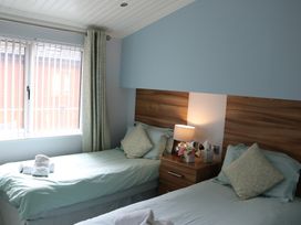 A bedroom with two single beds and a window at High View Lodge White Cross Bay near Troutbeck Bridge