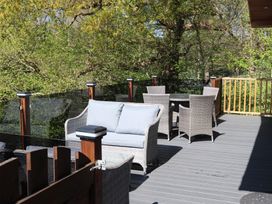 A deck with outdoor seating and a table at High View Lodge in White Cross Bay near Troutbeck Bridge