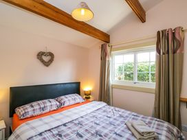 A bedroom with a bed pillow and blanket near a window with curtains at The Nook in Royal Wootton Bassett