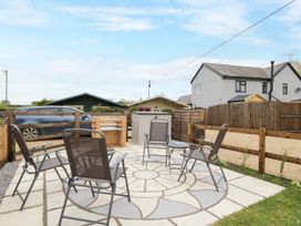 A garden patio with chairs and a car at The Nook in Royal Wootton Bassett