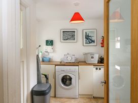 A laundry room with a washing machine and shelving at Rowantree in Beaufort, County Kerry