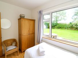 A bedroom with a wardrobe and a chair at Rowantree in Beaufort, County Kerry