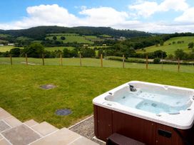 An outdoor area with a hot tub and a view of the landscape at Tyn Y Celyn Canol in Clocaenog near Ruthin