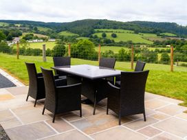 A table and chairs on a stone patio at Tyn Y Celyn Canol Clocaenog near Ruthin