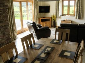 A living room with a sofa and dining area at Tyn Y Celyn Canol Clocaenog near Ruthin