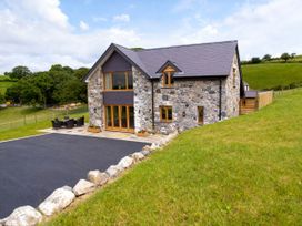 A house with a stone exterior and outdoor dining area at Tyn Y Celyn Canol in Clocaenog near Ruthin
