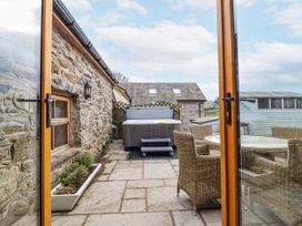 A patio with a hot tub and dining area at Briws and 963354 together they sleep 35