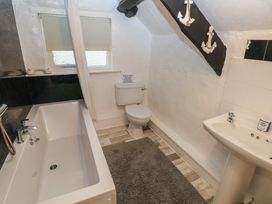 A bathroom with a bath, toilet, and sink at Maesgwyn in Bridell near Cardigan