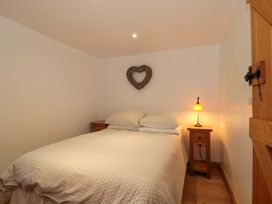 A bedroom with a bed and nightstand at Riverside Barn in Gilwern near Crickhowell and Abergavenny