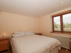 A bedroom with a bed and dresser at Riverside Barn in Gilwern near Crickhowell and Abergavenny