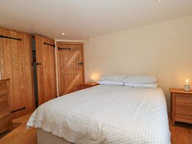 A bedroom with a bed and wooden furniture at Riverside Barn in Gilwern near Crickhowell and Abergavenny
